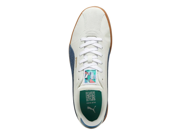 Tenis PUMA blancos con franja azul marino y suela de goma color café.