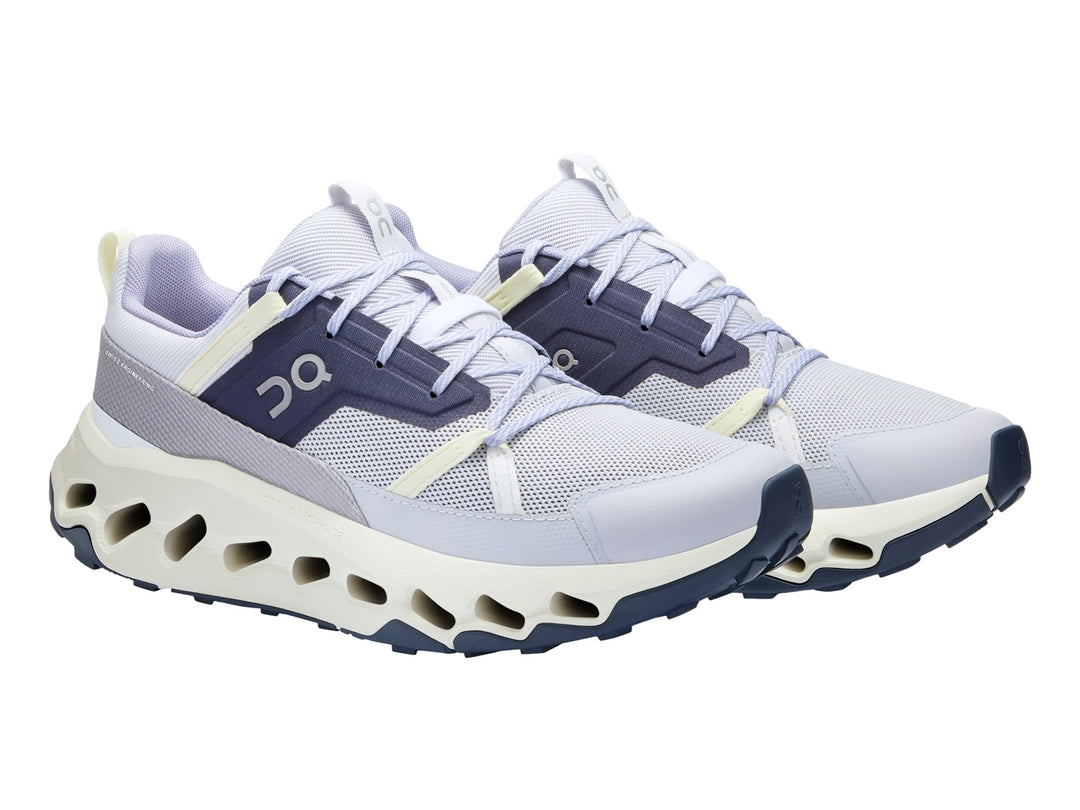 Tenis deportivos On Cloud en color lavanda e ivory con suela blanca característica de amortiguación.