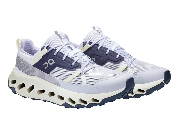 Tenis deportivos On Cloud en color lavanda e ivory con suela blanca característica de amortiguación.