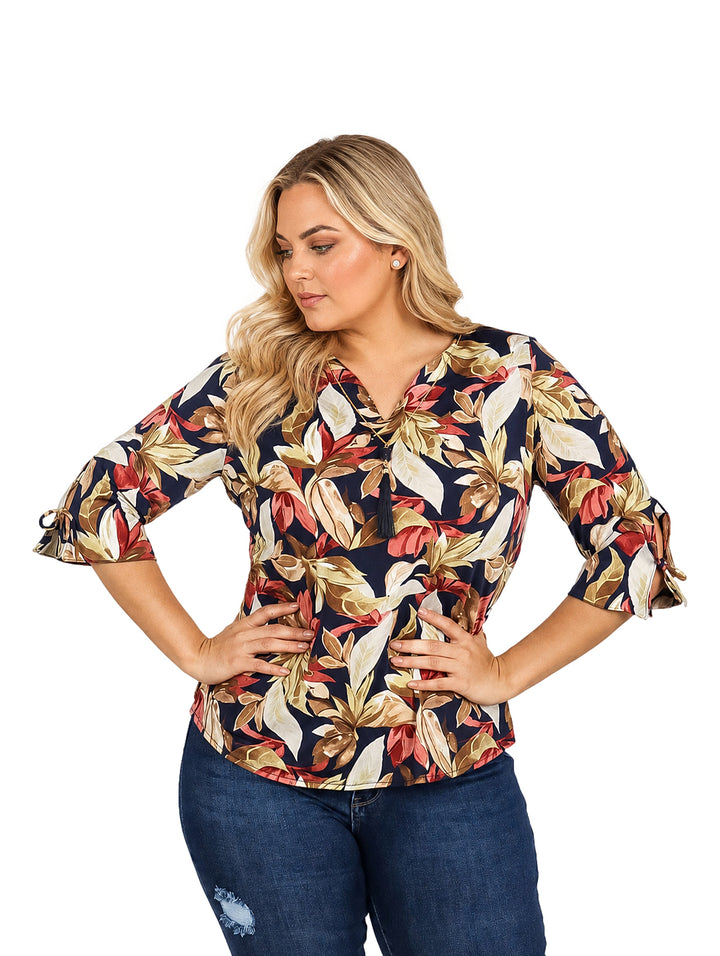 Mujer vistiendo blusa multicolor con estampado floral y mangas 3/4.