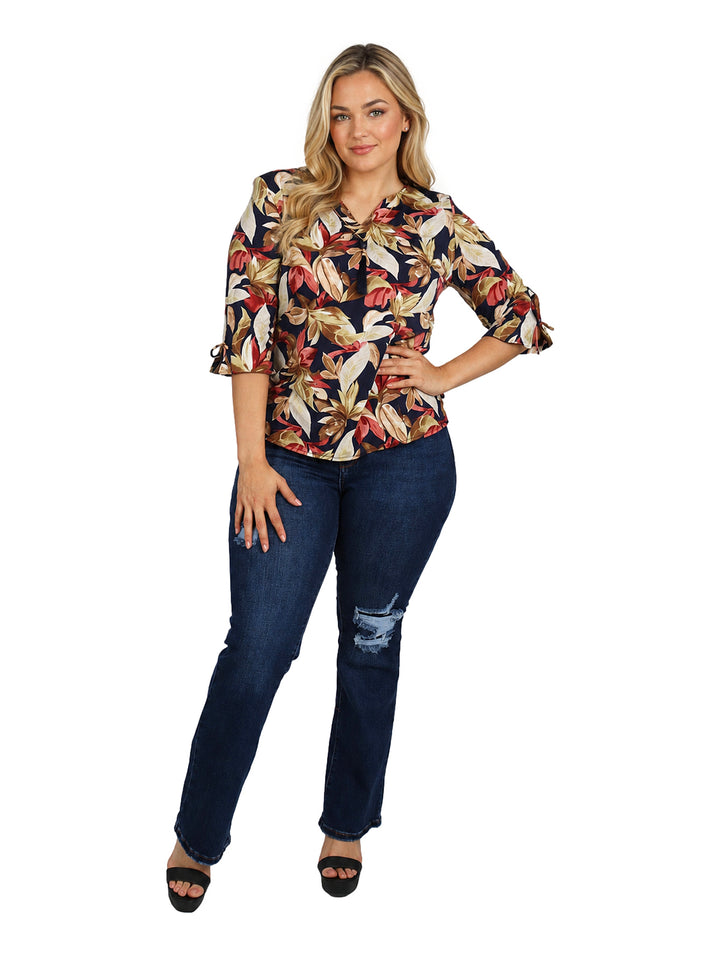Mujer vistiendo blusa multicolor con estampado floral y mangas 3/4.