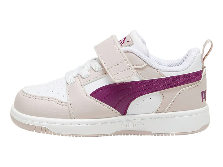 Tenis PUMA infantiles color malva y blanco con franja magenta y cierre de correa.