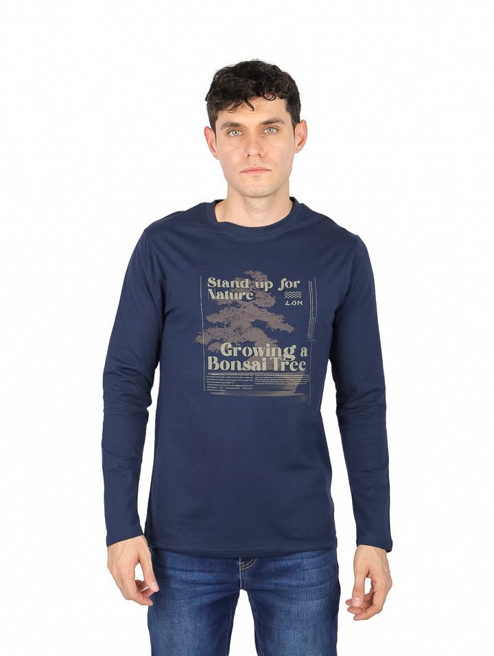 Hombre vistiendo camiseta de manga larga color azul oscuro con estampado gráfico frontal.