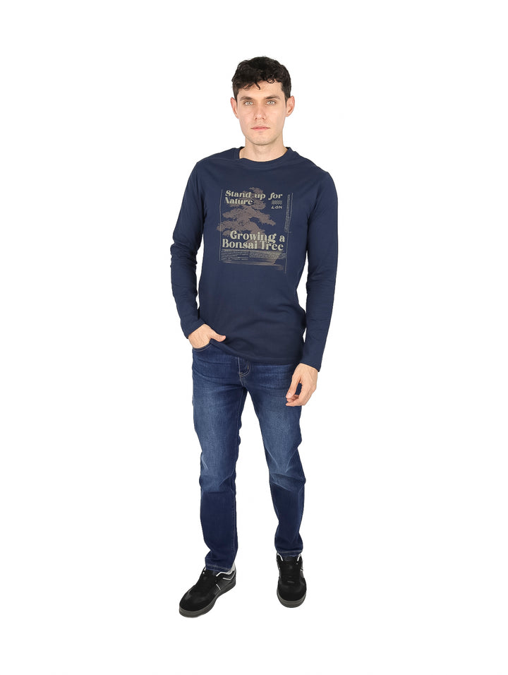 Hombre vistiendo camiseta de manga larga color azul oscuro con estampado gráfico frontal.