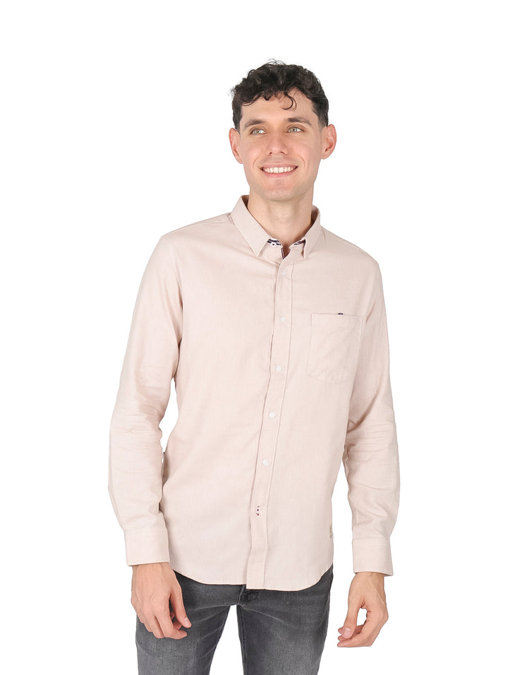 Hombre vistiendo una camisa casual de manga larga en color beige con un bolsillo frontal.