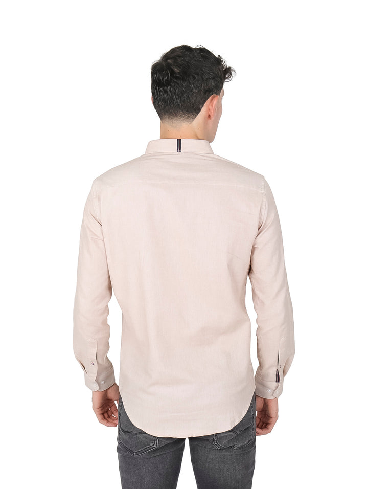 Hombre vistiendo una camisa casual de manga larga en color beige con un bolsillo frontal.