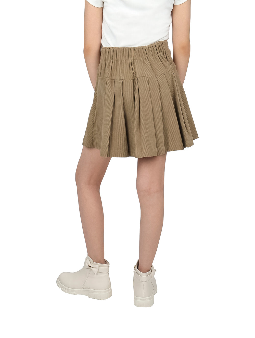 Niña vistiendo una falda plisada de color café panilla y botas blancas.