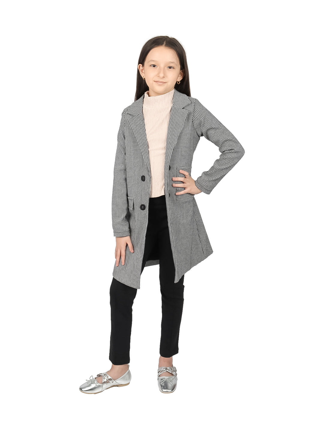 Niña vistiendo un blazer largo de color negro y blanco con estampado de cuadros y botones frontales.