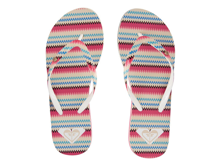 Sandalias planas Roxy con tiras en patrón de zigzag multicolor y suela negra con detalle rosa.