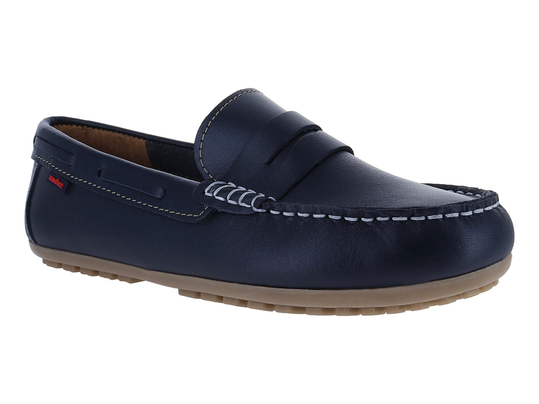 Zapato tipo mocasín para niño en color azul marino con suela beige y costuras blancas.