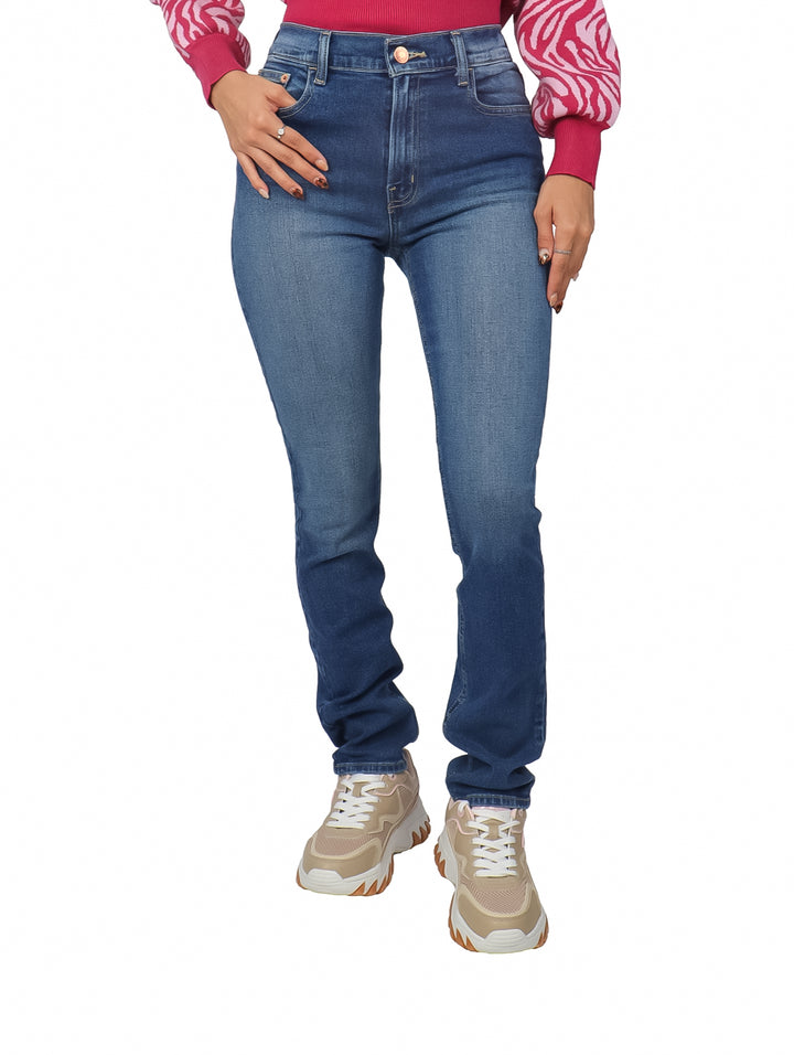Mujer vistiendo pantalones jeans rectos de color azul con efecto vintage y tenis beige.