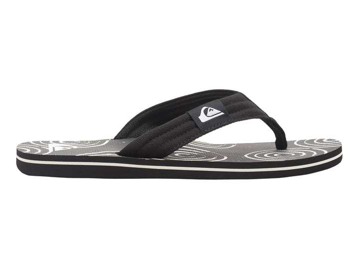 Sandalias Quiksilver negras con suela blanca y detalles gráficos en la plantilla.
