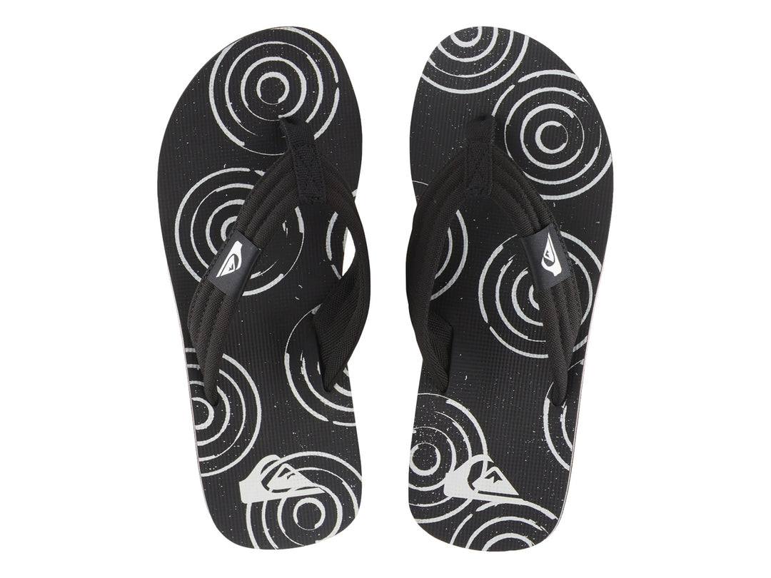 Sandalias Quiksilver negras con suela blanca y detalles gráficos en la plantilla.