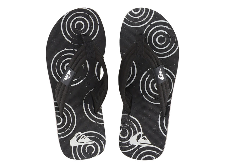 Sandalias Quiksilver negras con suela blanca y detalles gráficos en la plantilla.