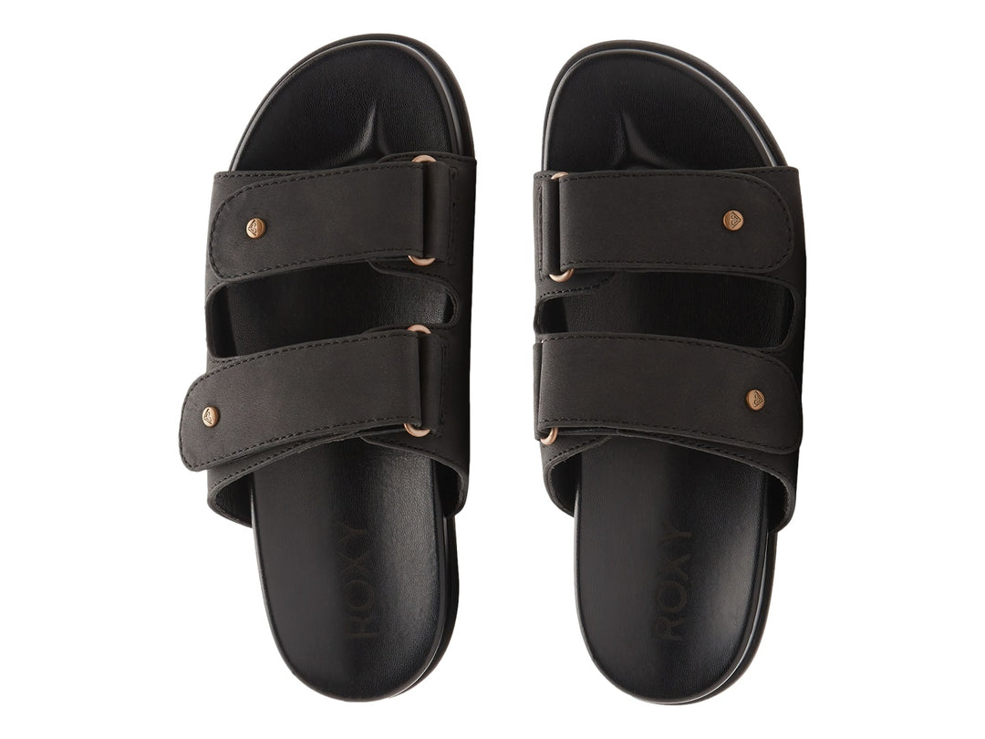 Sandalia slide negra con dos correas y botones decorativos dorados.