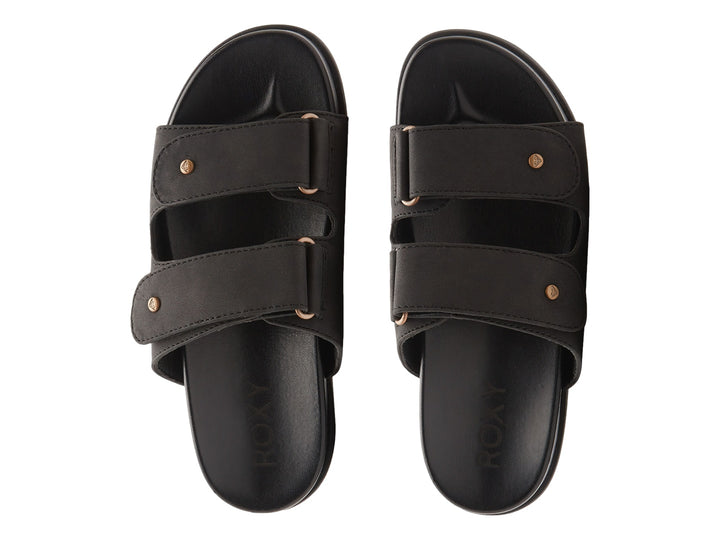 Sandalia slide negra con dos correas y botones decorativos dorados.