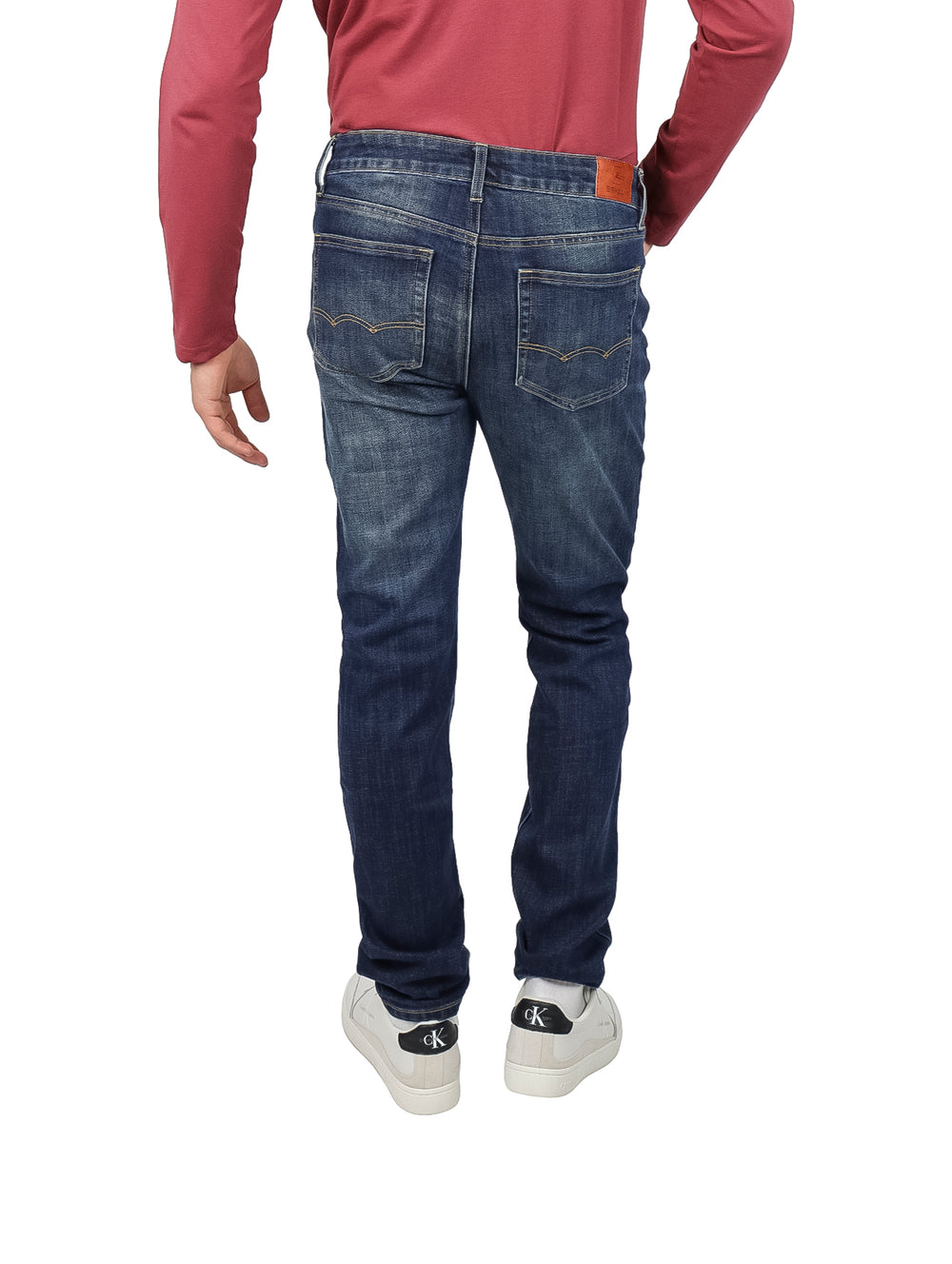 Hombre vistiendo pantalones de mezclilla color stone wash azul oscuro.