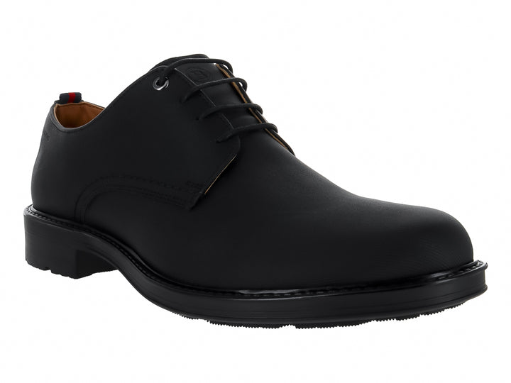 Zapato cerrado color negro de material sintético con cordones y suela plana.