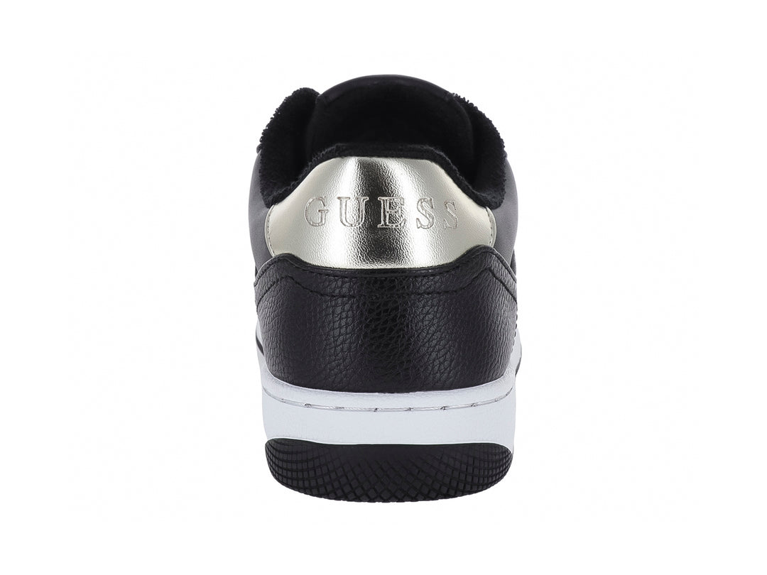 Tenis negros de la marca Guess con detalles decorativos en dorado y suela blanca.