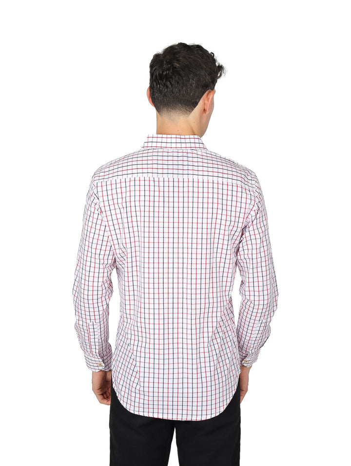 Hombre vistiendo una camisa de manga larga con estampado de cuadros rojos y azules sobre fondo blanco.