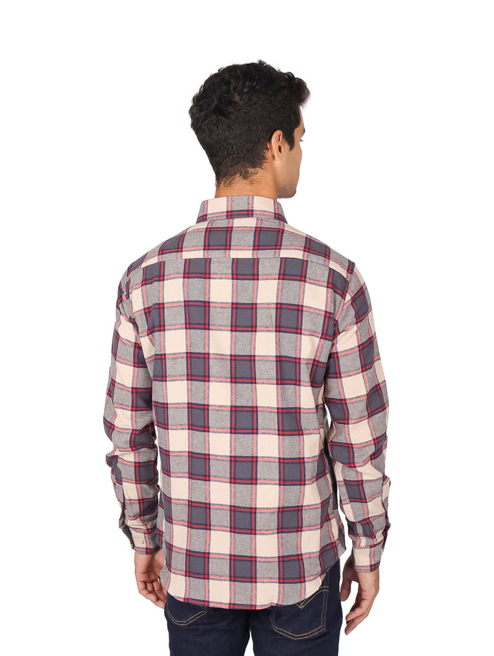 Hombre vistiendo camisa de franela a cuadros en colores beige y café con manga larga.