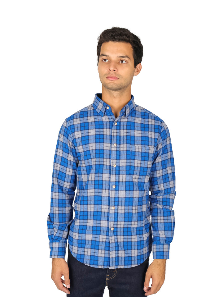 Hombre vistiendo una camisa de franela a cuadros en color azul y negro con manga larga.