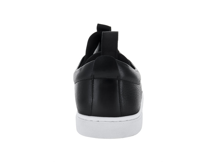 Zapato tipo slip-on de piel negra con suela blanca y pestaña trasera para calce fácil.