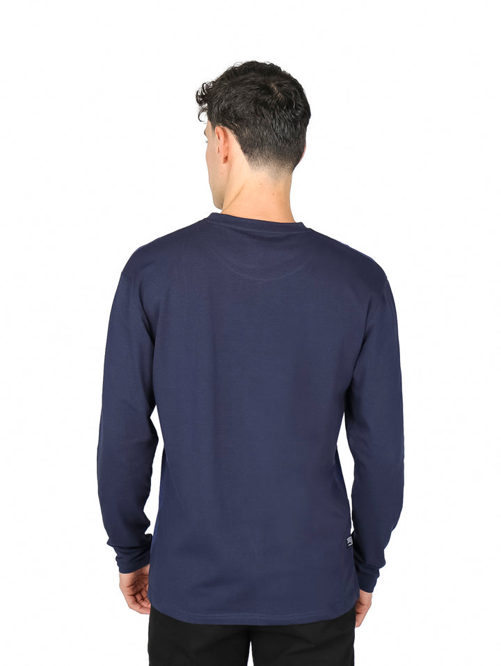 Hombre vistiendo playera de manga larga color azul marino con detalle de textura en la parte superior del pecho.
