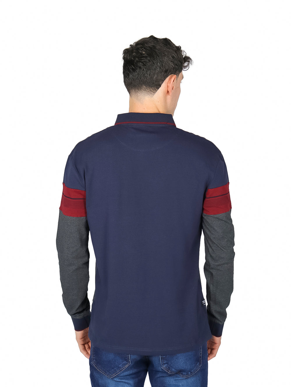 Hombre vistiendo playera polo de manga larga con bloques de color azul marino, guinda y gris carbón.
