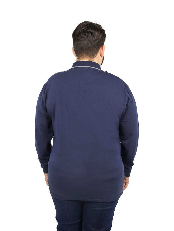 Hombre vistiendo una playera polo de manga larga en color azul marino con detalles en el cuello y puños.