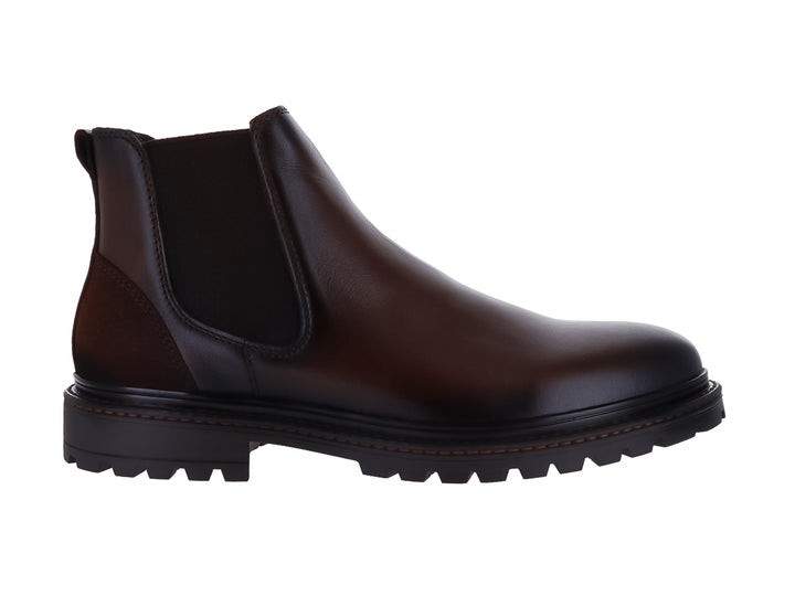 Botas estilo Chelsea de cuero color marrón oscuro con suela track negra y paneles elásticos laterales.