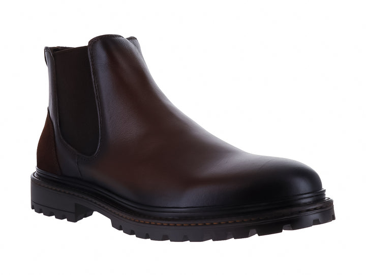 Botas estilo Chelsea de cuero color marrón oscuro con suela track negra y paneles elásticos laterales.