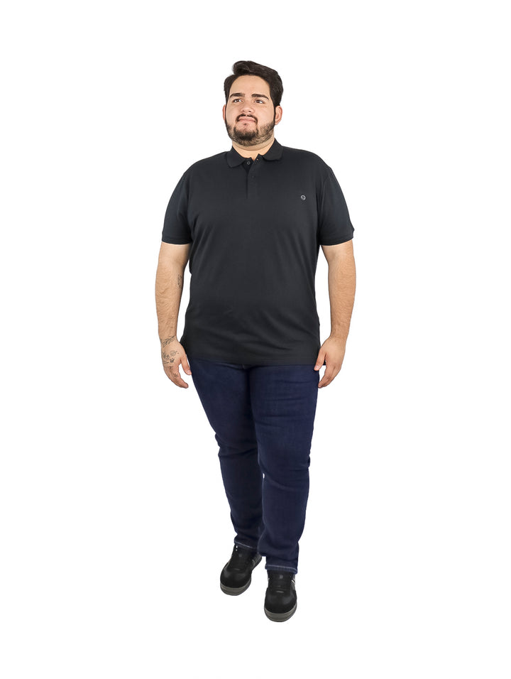 Hombre vistiendo una playera tipo polo de color negro de manga corta.