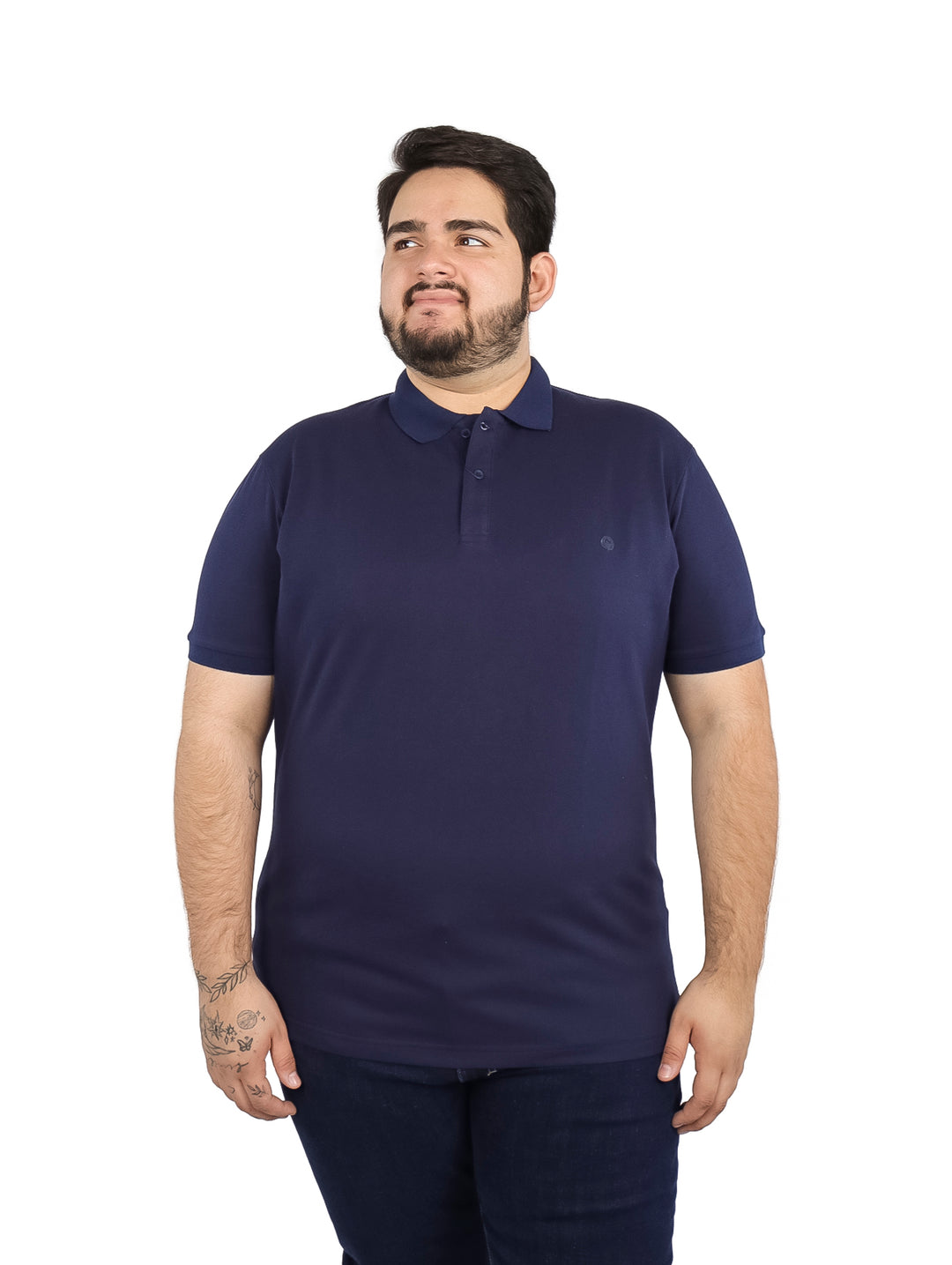 Hombre vistiendo una playera polo de color azul marino de manga corta.