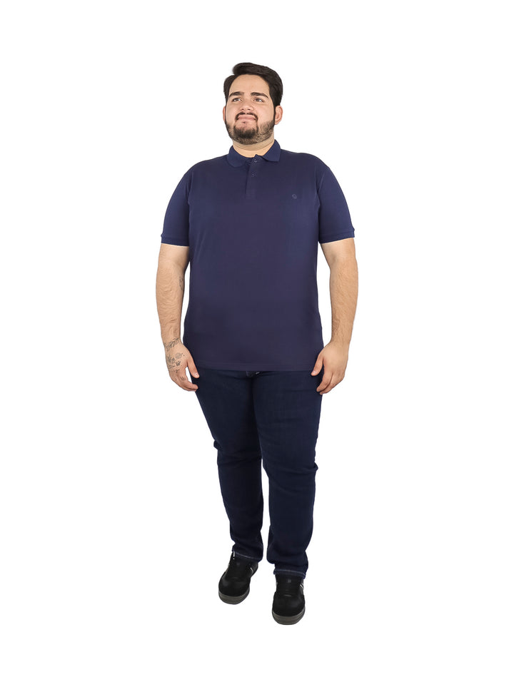 Hombre vistiendo una playera polo de color azul marino de manga corta.