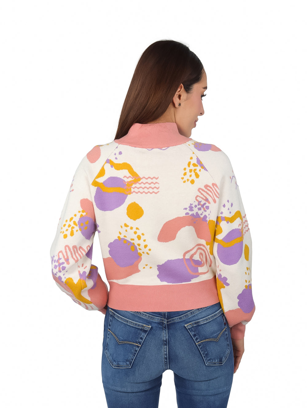 Mujer vistiendo un suéter tejido multicolor con estampado abstracto en tonos rosa, morado y amarillo.