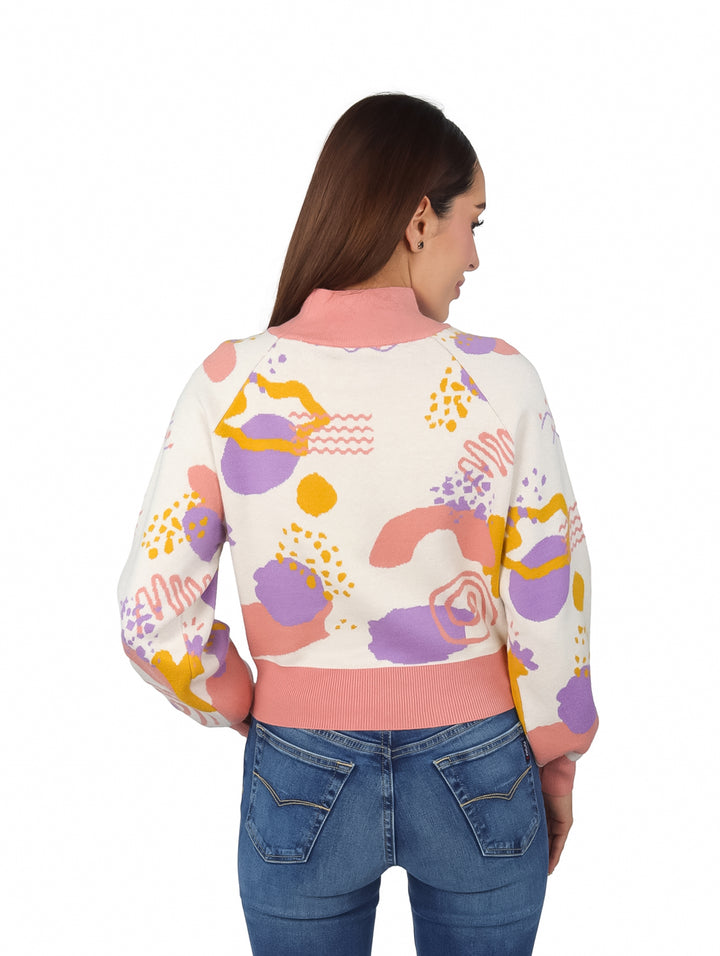 Mujer vistiendo un suéter tejido multicolor con estampado abstracto en tonos rosa, morado y amarillo.