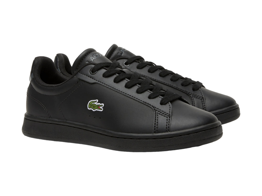 Tenis negros de cuero marca Lacoste para niños con logotipo del cocodrilo en el lateral.