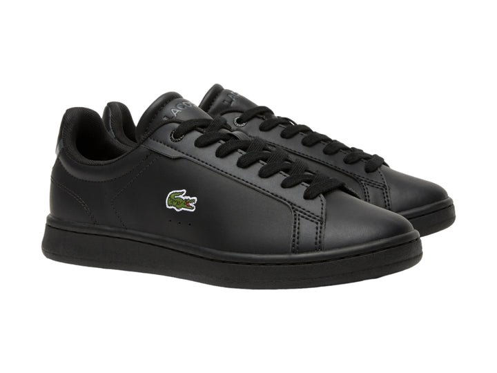 Tenis negros de cuero marca Lacoste para niños con logotipo del cocodrilo en el lateral.