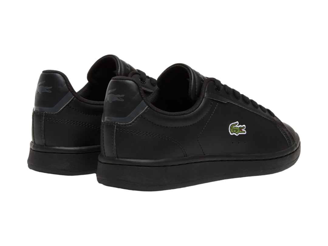 Tenis negros de cuero marca Lacoste para niños con logotipo del cocodrilo en el lateral.