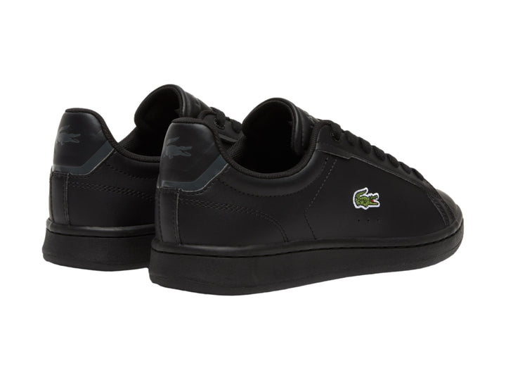 Tenis negros de cuero marca Lacoste para niños con logotipo del cocodrilo en el lateral.