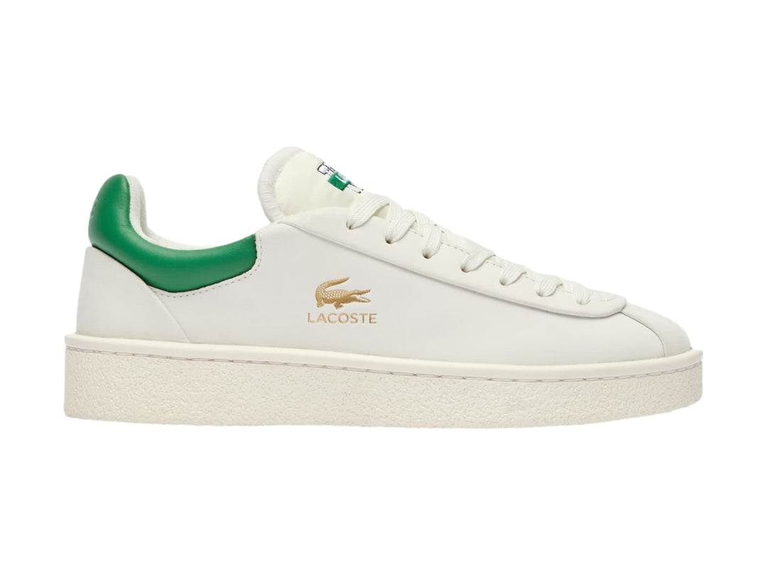 Tenis Lacoste blancos con talón verde y logotipo dorado en el costado.
