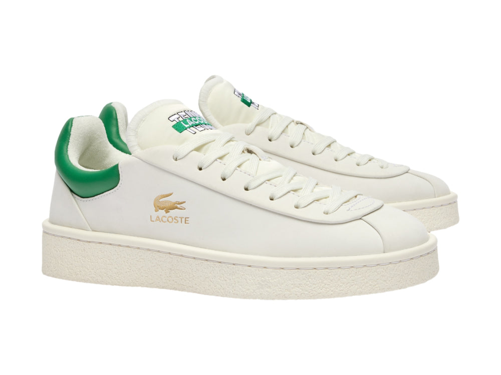 Tenis Lacoste blancos con talón verde y logotipo dorado en el costado.