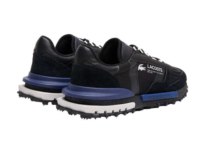 Tenis deportivos Lacoste en color negro con detalles en azul marino y suela blanca y negra.