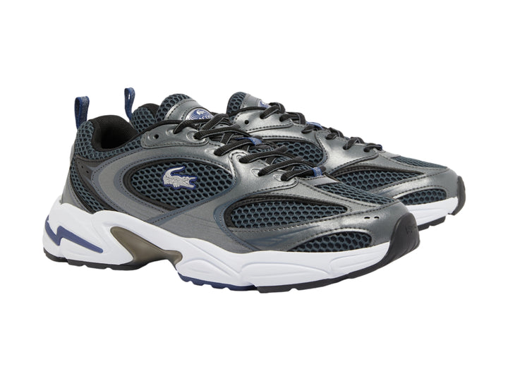 Tenis deportivos Lacoste en color gris oscuro y azul marino con suela blanca robusta.