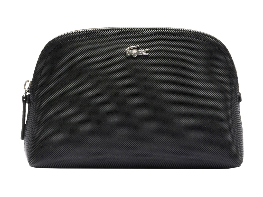 Bolso pequeño de color negro con textura granulada y logotipo metálico de Lacoste en el centro.