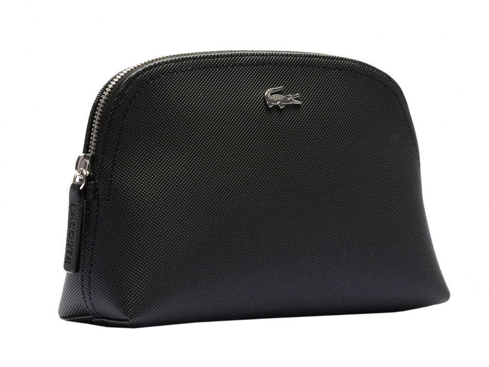 Bolso pequeño de color negro con textura granulada y logotipo metálico de Lacoste en el centro.