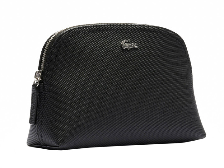 Bolso pequeño de color negro con textura granulada y logotipo metálico de Lacoste en el centro.