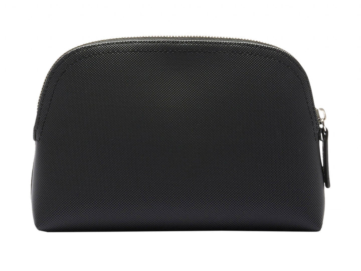 Bolso pequeño de color negro con textura granulada y logotipo metálico de Lacoste en el centro.