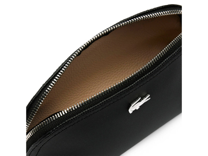 Bolso pequeño de color negro con textura granulada y logotipo metálico de Lacoste en el centro.
